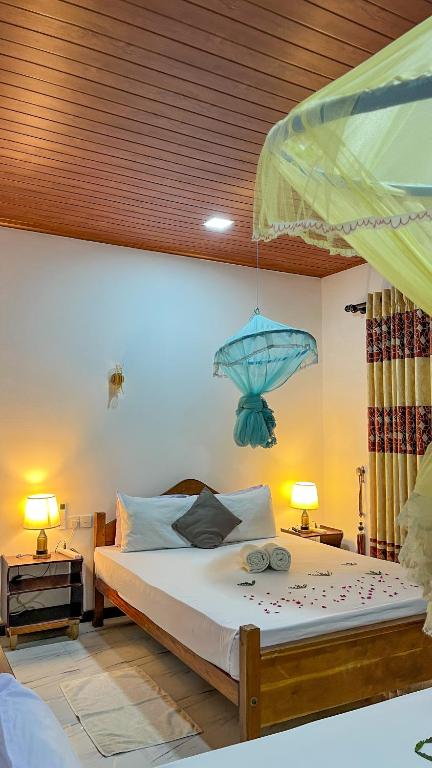 a bedroom with a bed with a blue item hanging from the ceiling at Horizon Resort & Hostel Sigiriya in Sigiriya