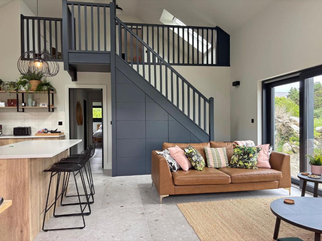 a living room with a couch and a staircase at Cottage 505 - Roundstone in Roundstone
