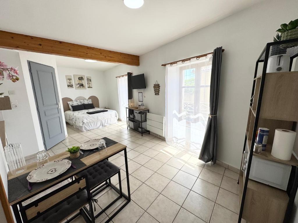 a living room with a table and a bed at Studios modernes & confort à Valence, Drôme in Valence