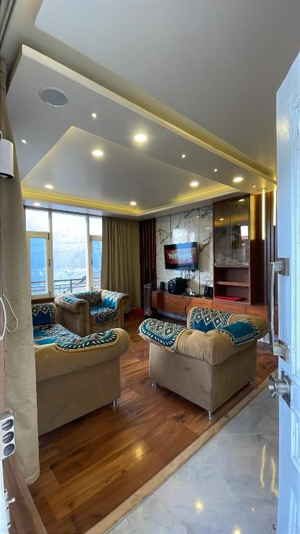 a living room with two couches and a television at Monkeys Junction in Manāli
