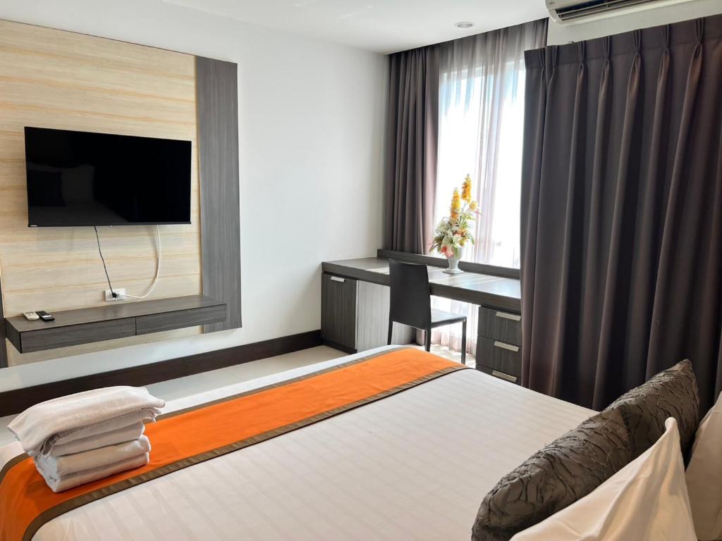 ein Hotelzimmer mit Bett und Schreibtisch in der Unterkunft Crystal Suites Suvarnbhumi Airport in Lat Krabang