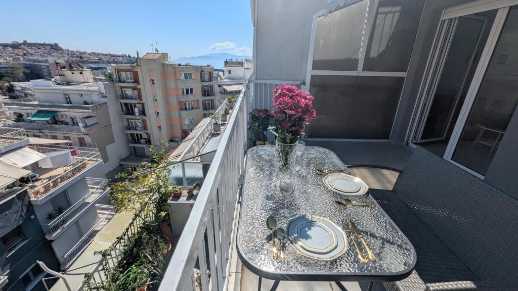 a table on a balcony with a vase of flowers at City Flights in Kavála