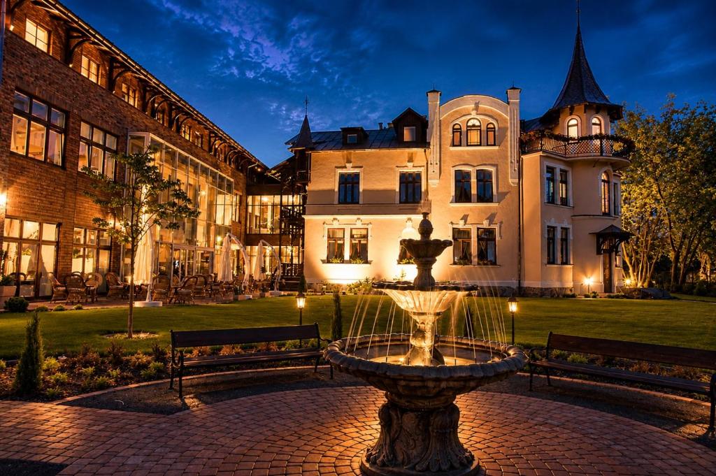 a fountain in front of a large building at Pensjonat Pod Jemiołą in Ciechocinek