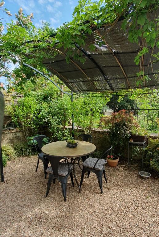 a table and chairs sitting under an umbrella at Appartement Saint Antoine 2 in Toulon-sur-Arroux
