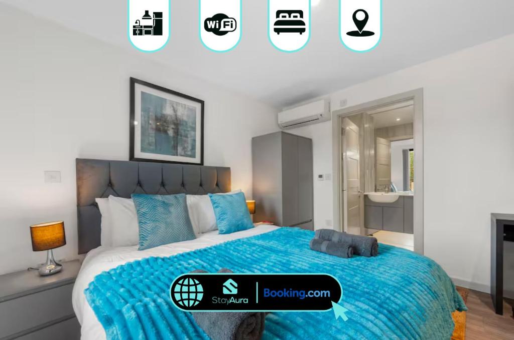 a bedroom with a bed with a blue comforter at Duplex 2BR Flat with Parking Near Excellent Transport Links By Stay Aura Short Term Lets Brentford in Brentford
