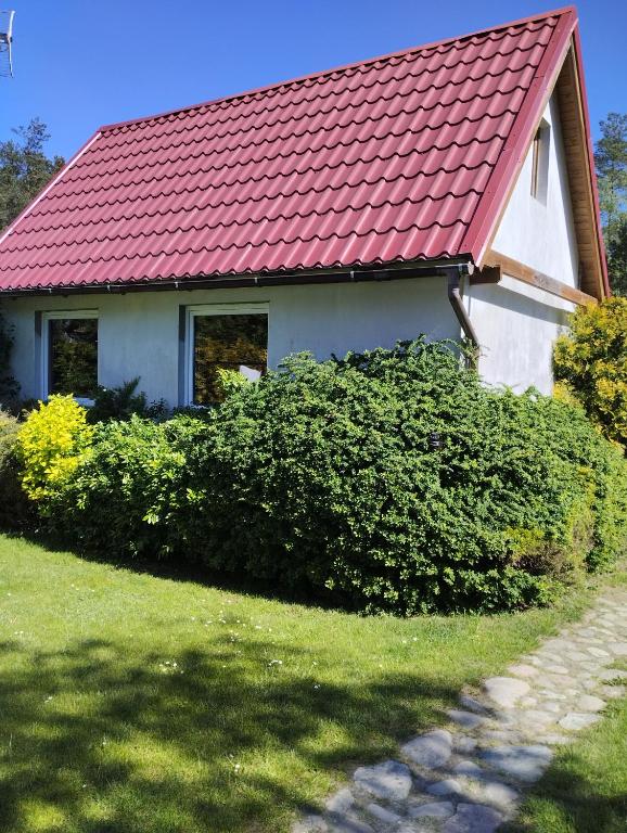 a white house with a red roof at Domek Karola in Bak