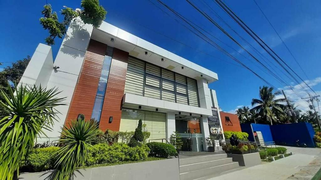 a building with palm trees in front of it at Wyndale Hotel in Camalig