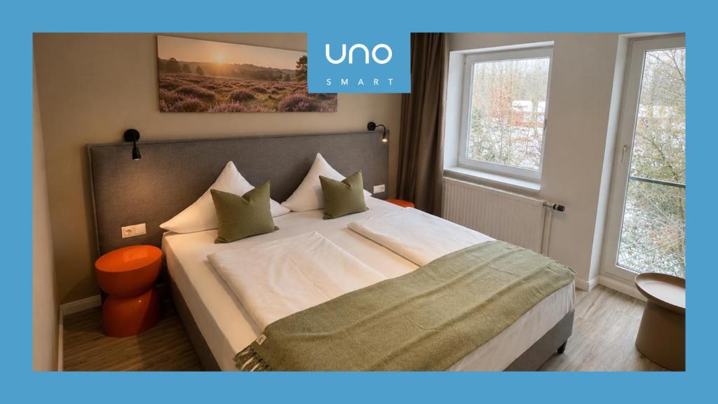 a bedroom with a large bed with white sheets and pillows at UNO Smart Soltau Wietzendorf in Soltau