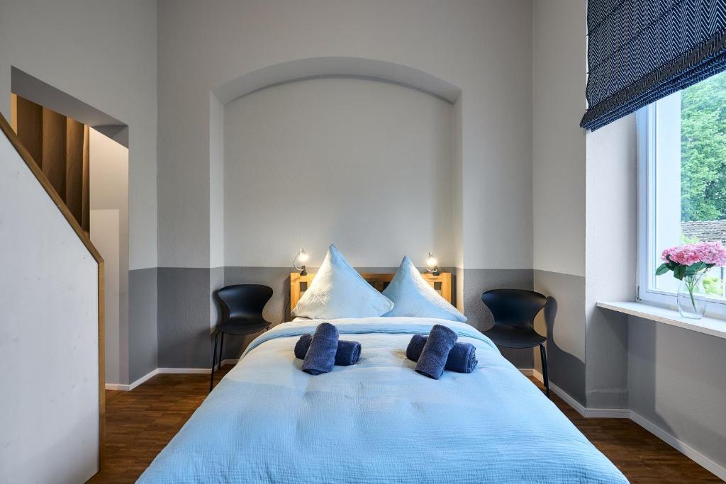 a bedroom with a large blue bed with blue pillows at seeglueck Altstadt Urban in Konstanz