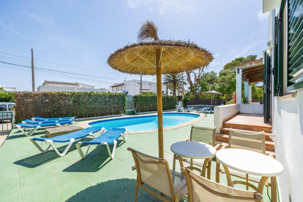 a patio with tables and chairs next to a swimming pool at Apartamento Felipe 2-1 in Cacla D'or