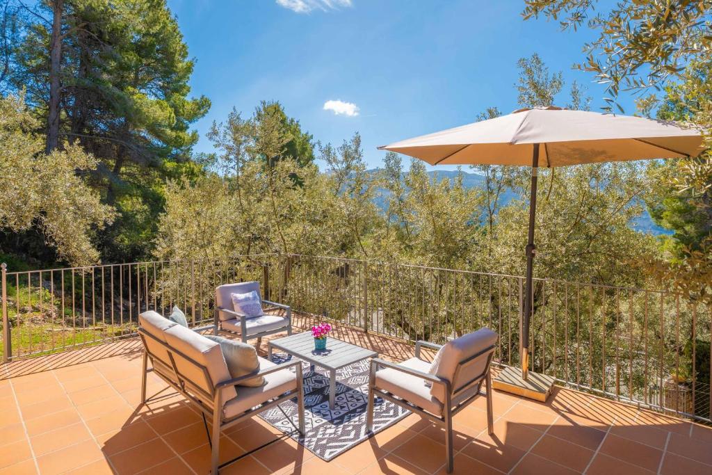 a patio with two chairs and an umbrella at Es Coll d'en Pastor in Fornalutx