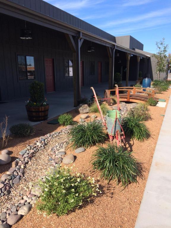 un jardin en face d'un bâtiment avec un banc dans l'établissement HH Creek Inn, à Seymour