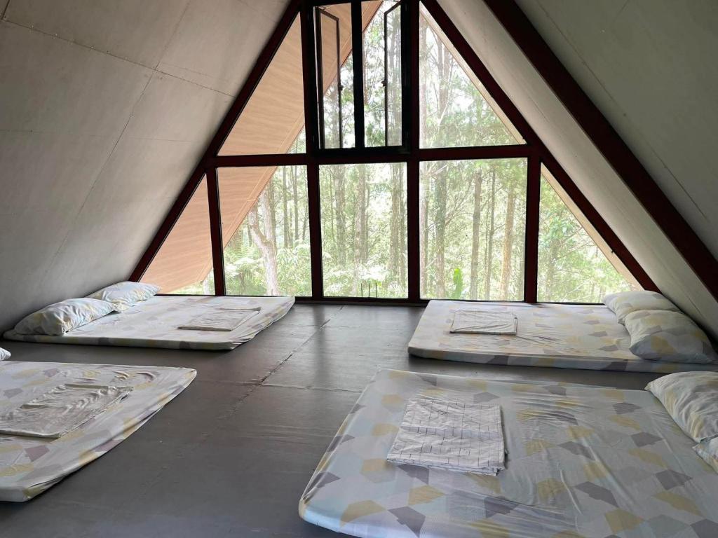 three beds in a room with large windows at Pine's View Casa Isabel Villa Staycation - Marilog, Davao City in Kayagan