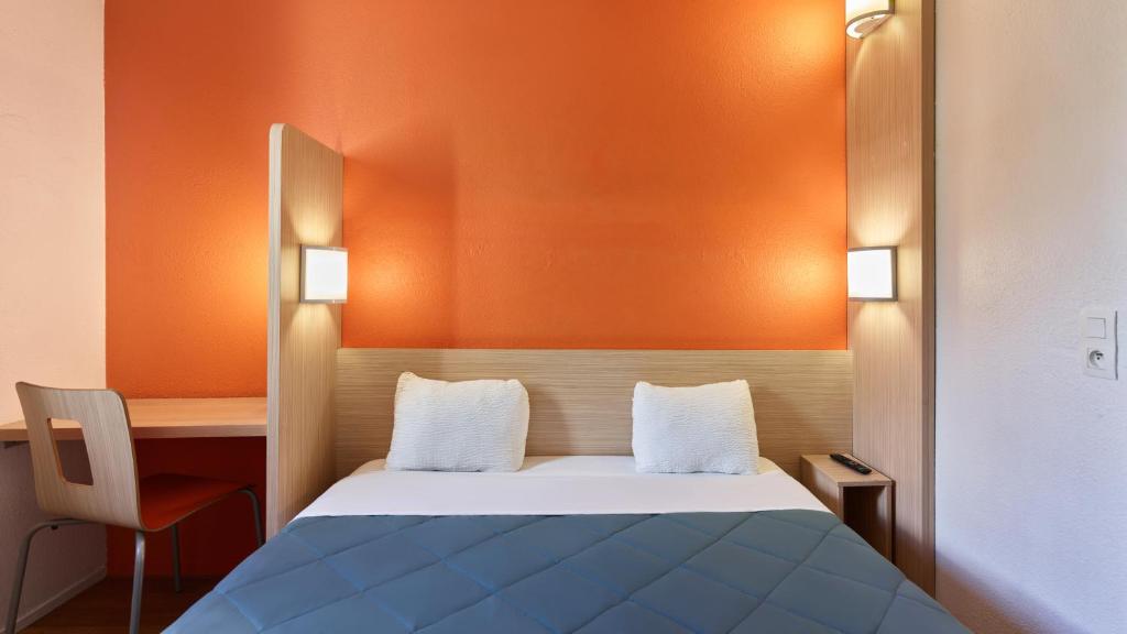 a bedroom with a bed and a desk and a chair at Première Classe Rosny Sous Bois in Rosny-sous-Bois