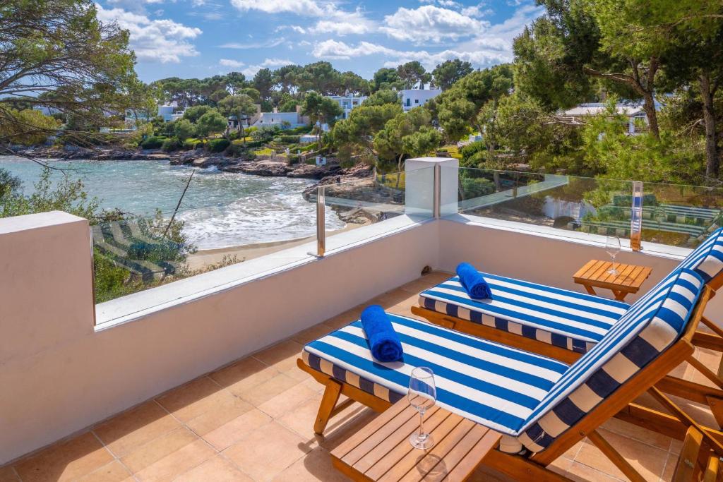 a balcony with two chairs and a view of the water at Cala Dor 14 in Cala d´Or
