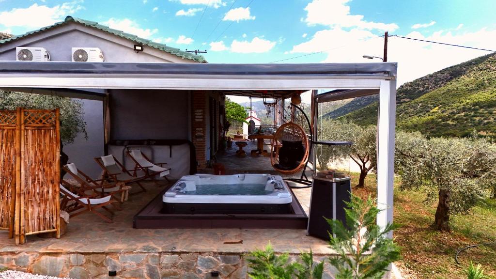 a house with a hot tub on a patio at Elaia Rest House Retreat in nature in Fréngaina