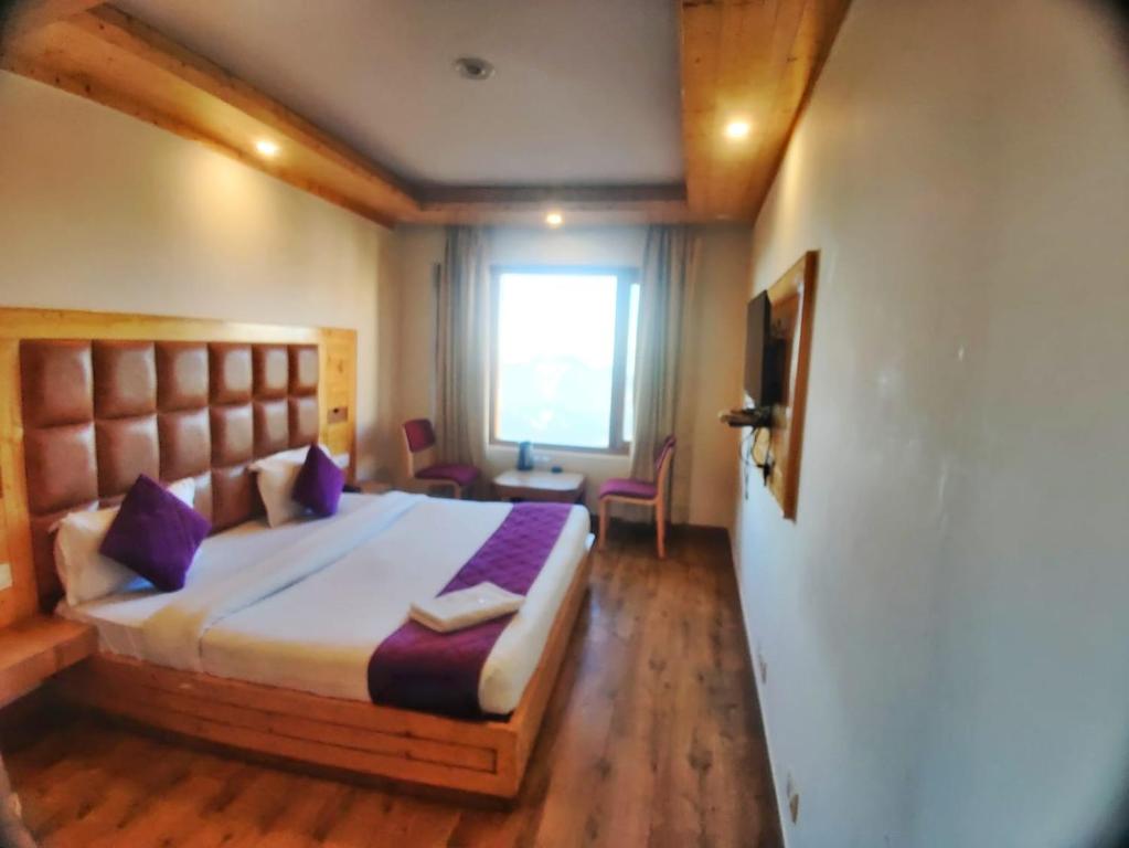 a bedroom with a large bed with purple pillows at Hans Cottage in Shimla