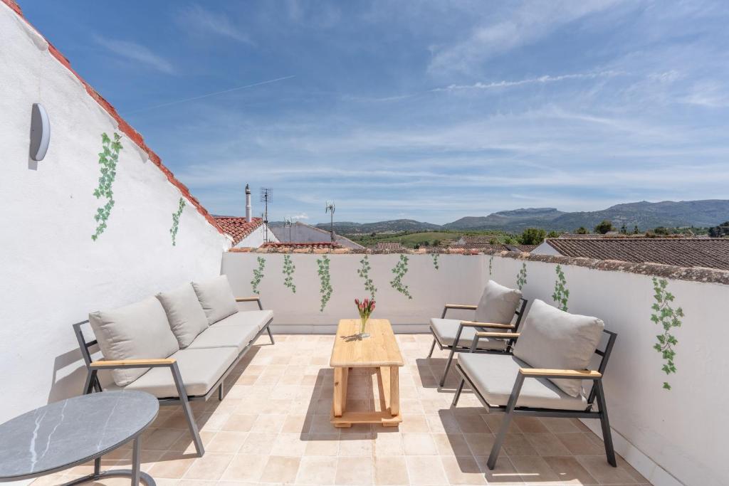 a patio with chairs and a table on a roof at Apartamento Casa Sol Ronda in Ronda