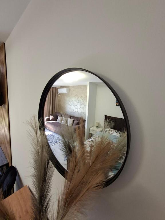 a mirror hanging on a wall with a bedroom at Casa Bon Relax , Rooms&Apartaments in Tuzla