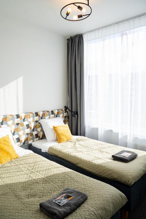 a bedroom with two beds and a window at KVARC Hotel in Valmiermuiža