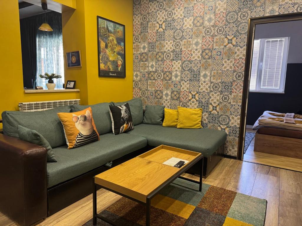 a living room with a green couch and a table at Trakia Street Apartment in Plovdiv