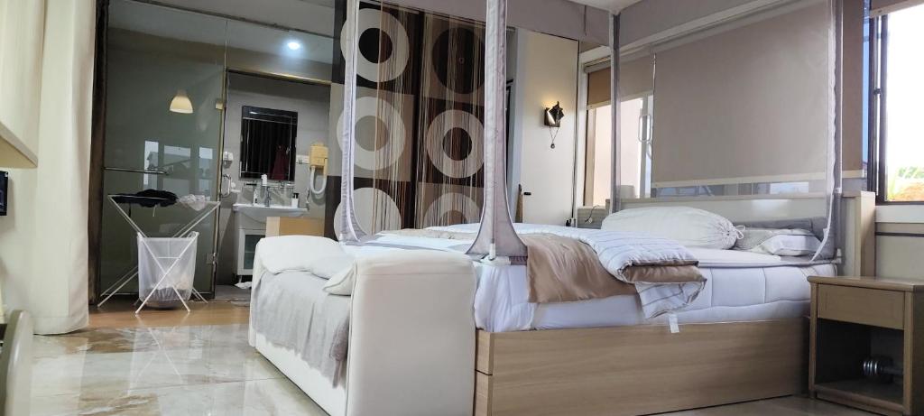 a bedroom with a white bed and a mirror at Mitra @Guesthouse B28-S in Batam Center