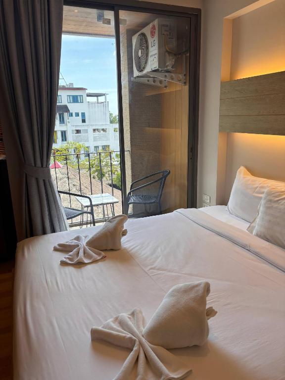 a hotel room with a bed with towels on it at Coconut Studio Aonang in Ao Nang Beach