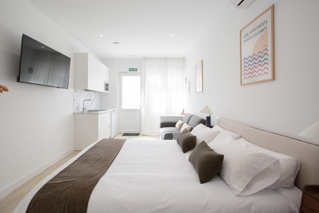 a bedroom with a large white bed with pillows at Urbil Puente Colgante in Portugalete