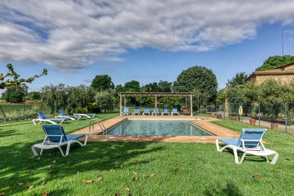 a group of chairs sitting in the grass by a pool at Mas Pareta - La Morera in Fonolleras