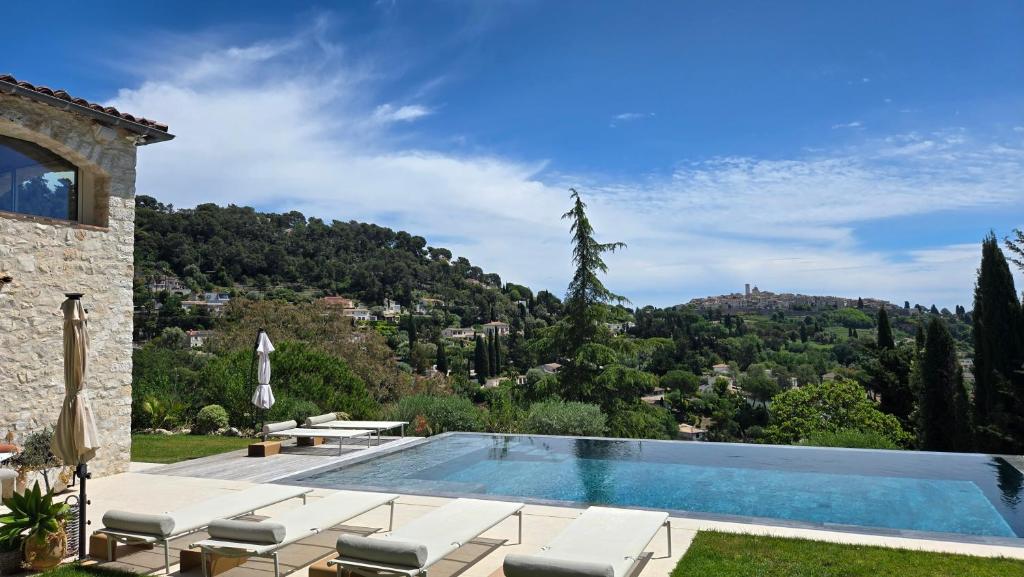 a villa with a swimming pool and a mountain at Ideal BnB, Luxury Apartments in Saint Paul de Vence