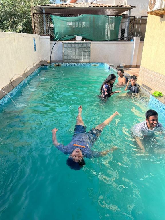 a group of people swimming in a swimming pool at Jannat Villa by Book Ur Stay in Lonavala
