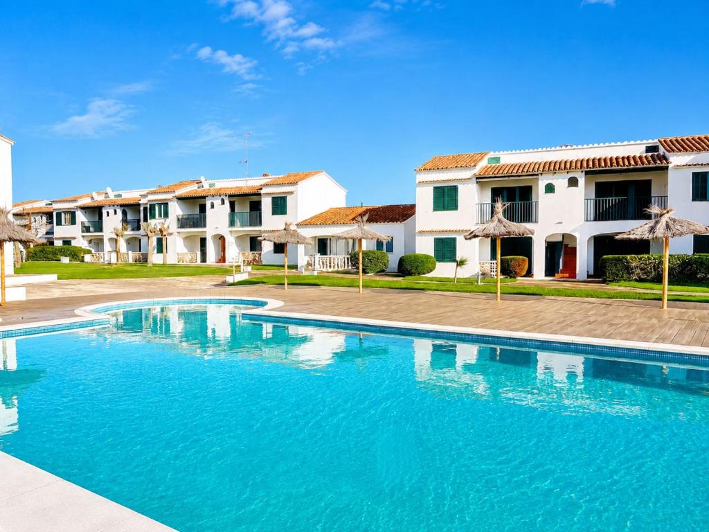 a swimming pool in front of some houses at Cala Porter Brise Marine in Cala en Porter