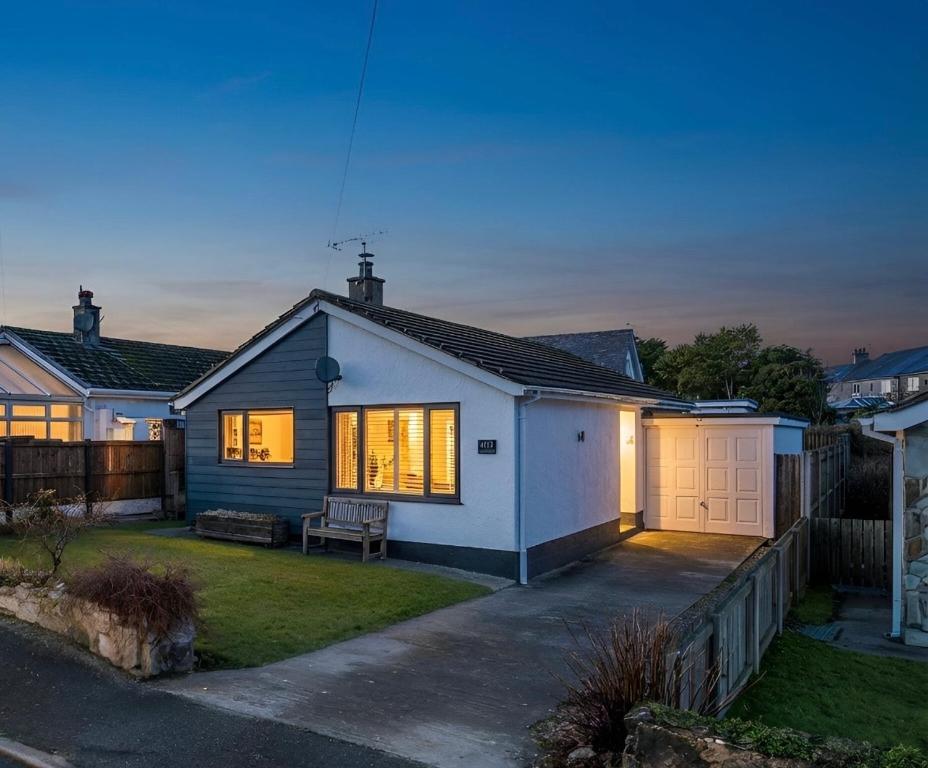 a white house with a fence in front of it at No 1 Rhosffordd in Moelfre
