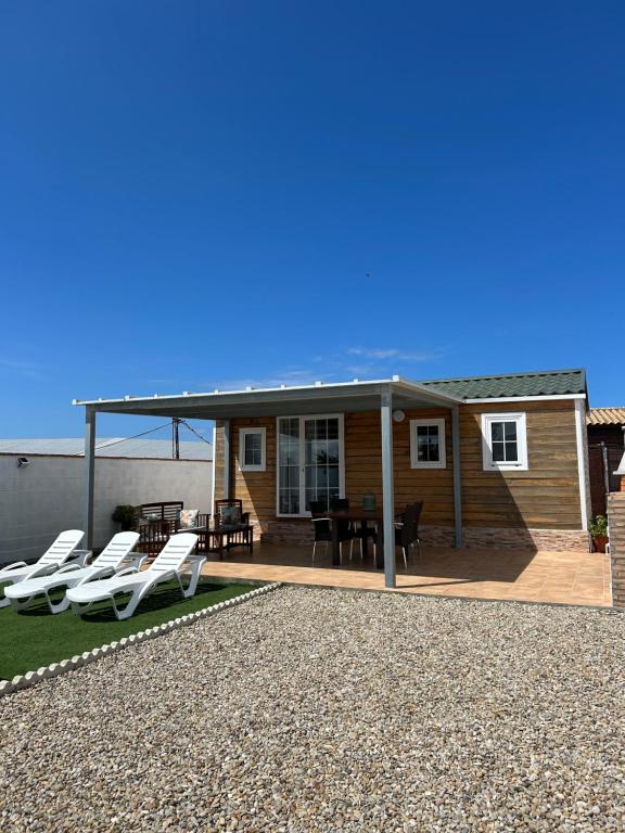 a house with a patio with white lounge chairs at Casita la Loma in Cádiz