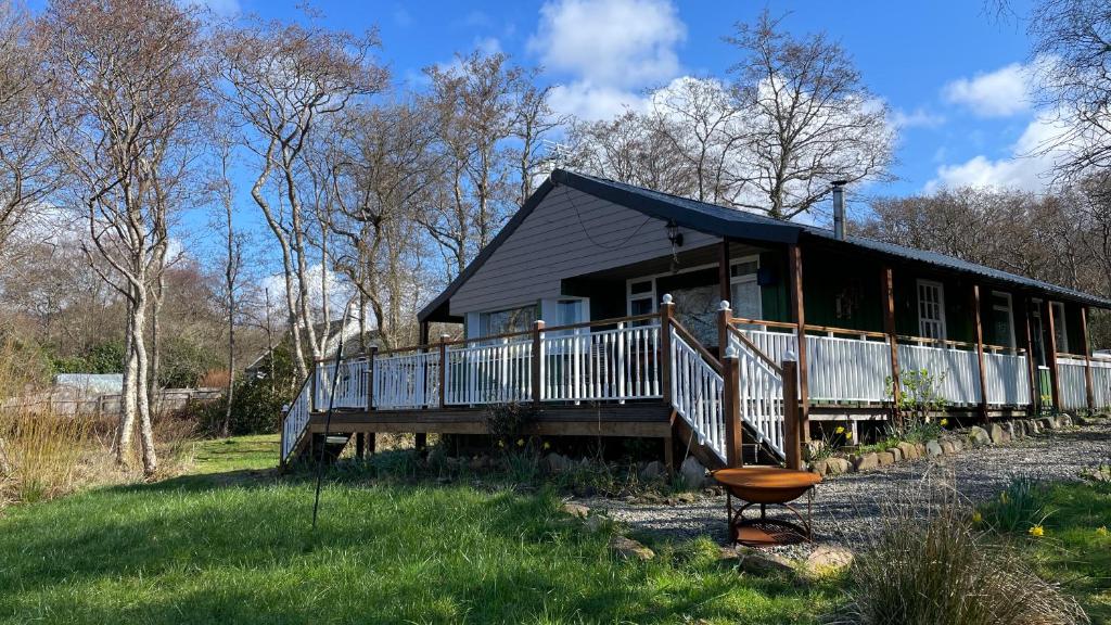 a house with a porch and a chair in front of it at Beachcombers in Craobh Haven