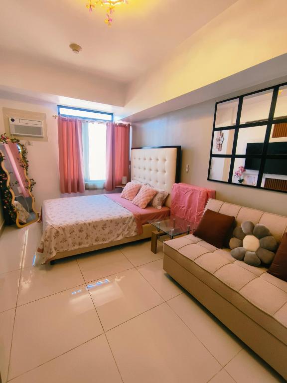 a bedroom with a bed and a couch at Arc tower- Sweet Stay Cebu in Cebu City