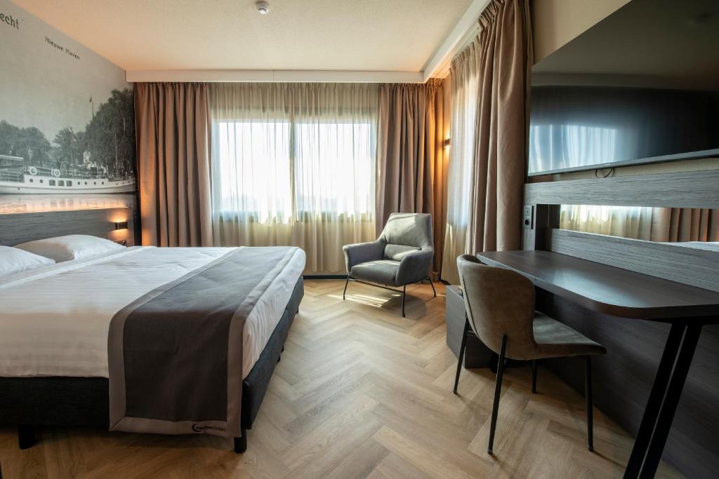 a hotel room with a bed and a desk at Bastion Hotel Dordrecht Papendrecht in Dordrecht