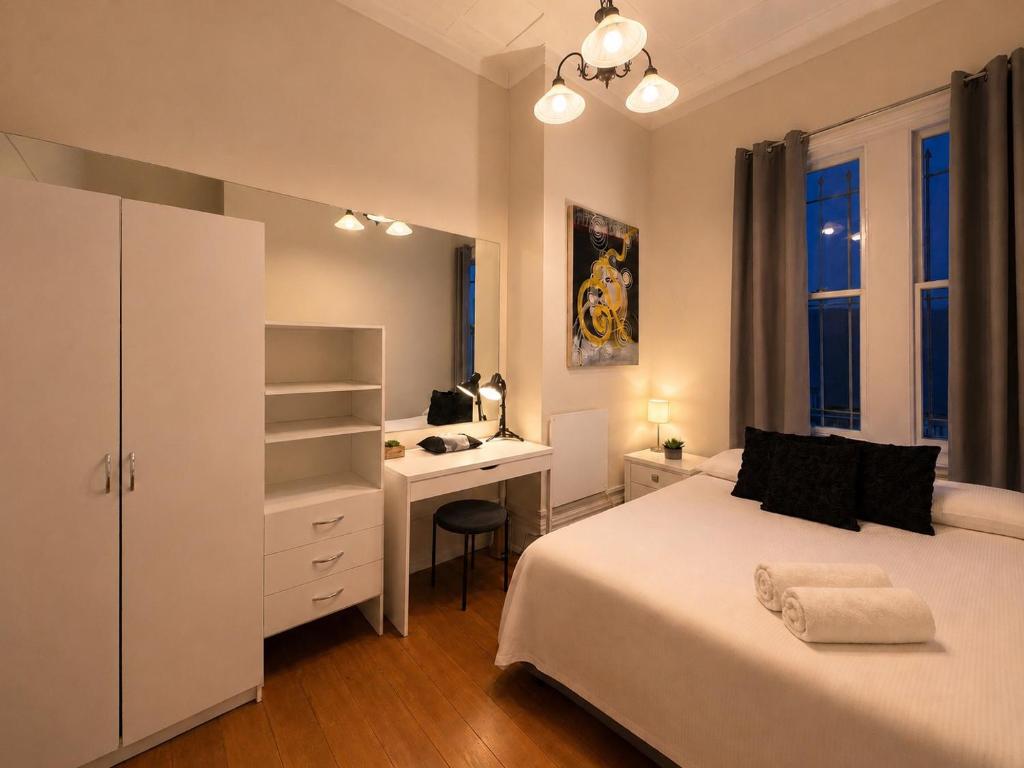 a bedroom with a bed and a desk and a deskablish at CitiRooms Auckland in Auckland
