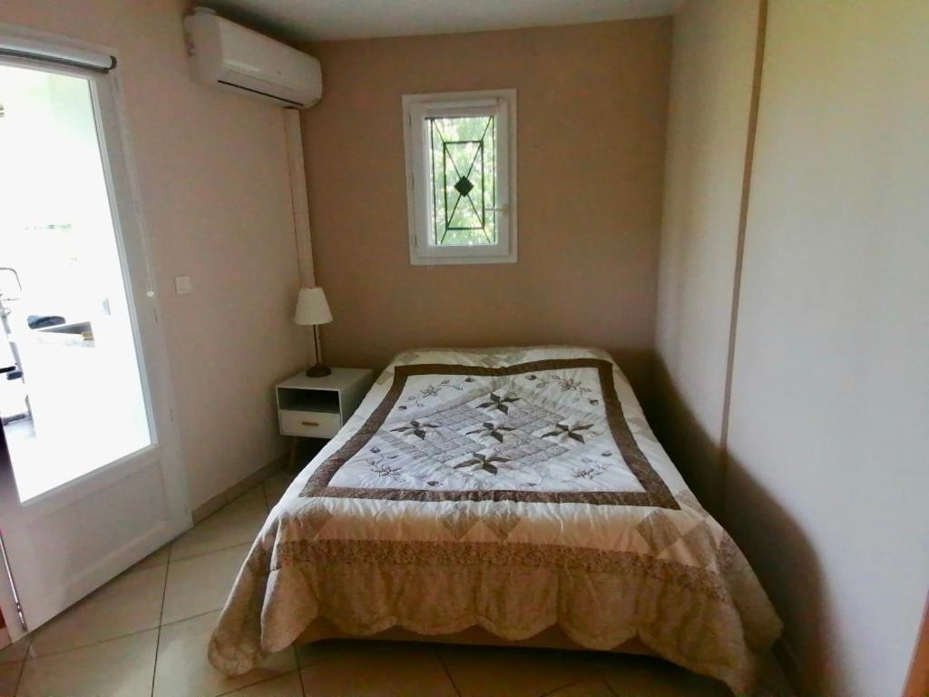 a bedroom with a bed and a window at Gîte Bouconne Pibrac in Pibrac