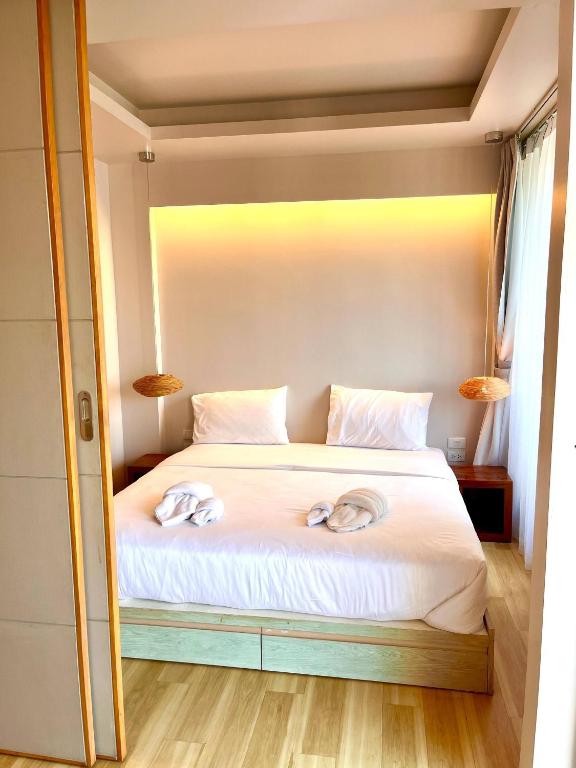 a bedroom with a bed with two towels on it at Coconut Suite Aonang in Ao Nang Beach