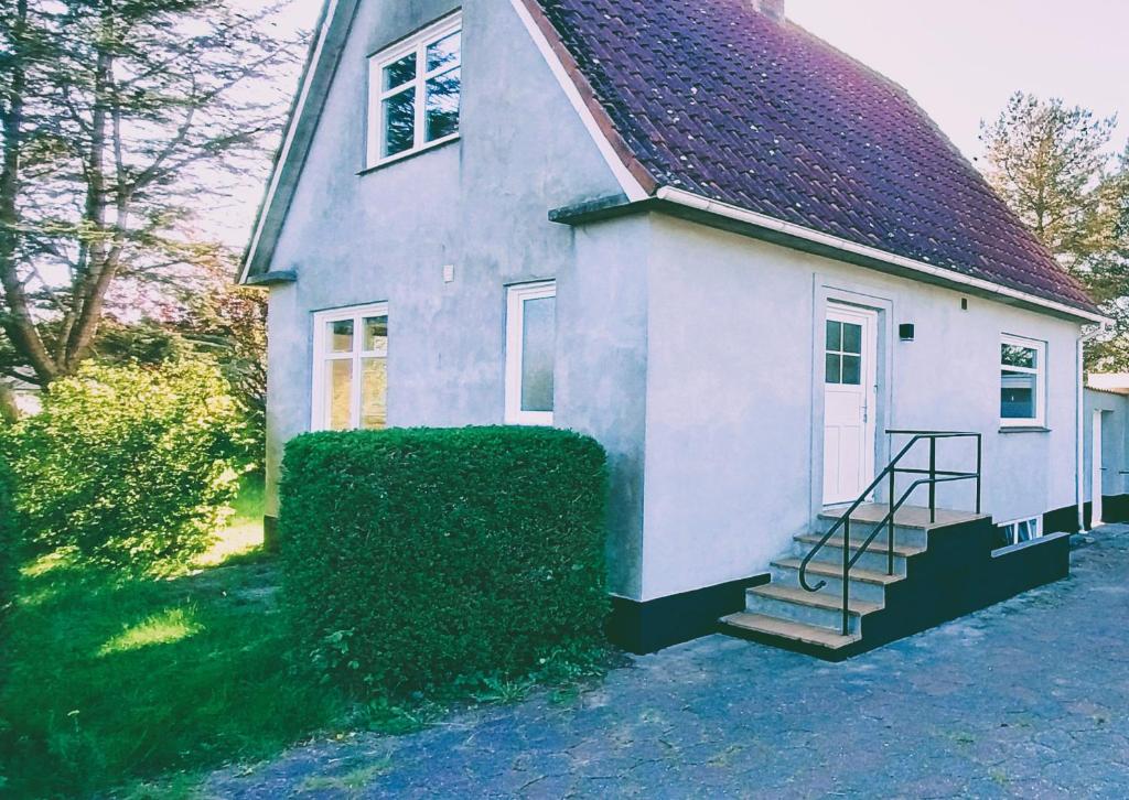 a small white house with a staircase in front of it at M1 Stay in Bevtoft