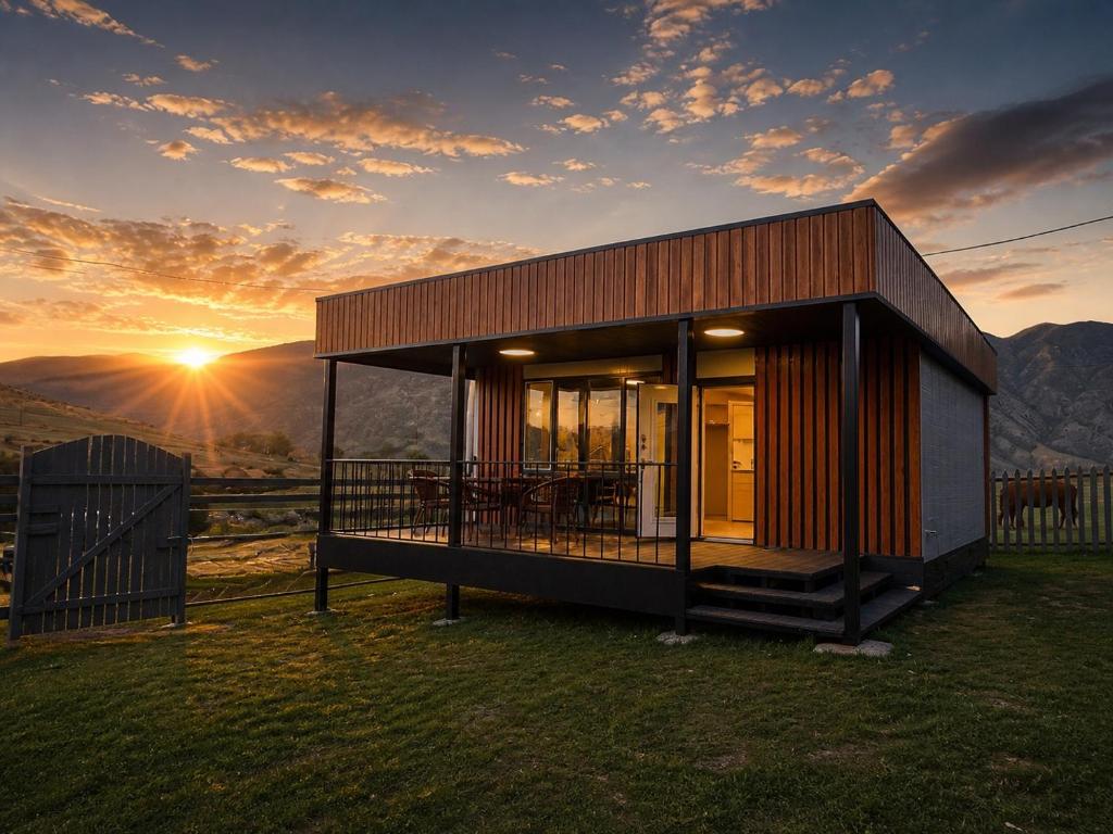 a small house on top of a hill with the sunset at Opensky-kolsay 2 in Saty