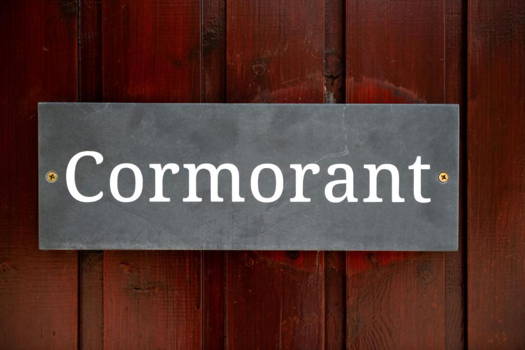 a sign on a wooden wall with the word concurrent at L23 Cormorant in Truro