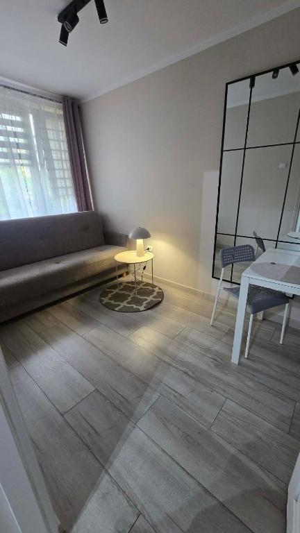 a living room with a couch and a table at Via VOLTA 2025 Refresh 2 Bedroom Apartment in Płock