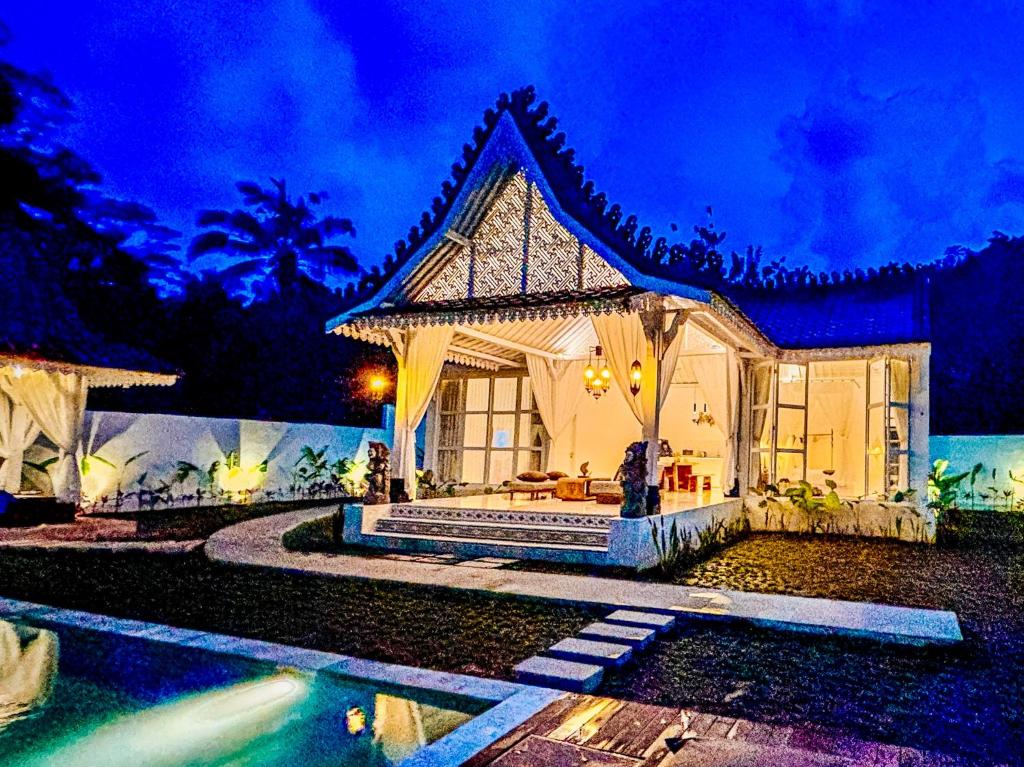 a house with a pool in front of it at night at Hafrana Villa by AGATA - 700sqm 2BR Villa with Private Pool & Jacuzzi in Sidemen