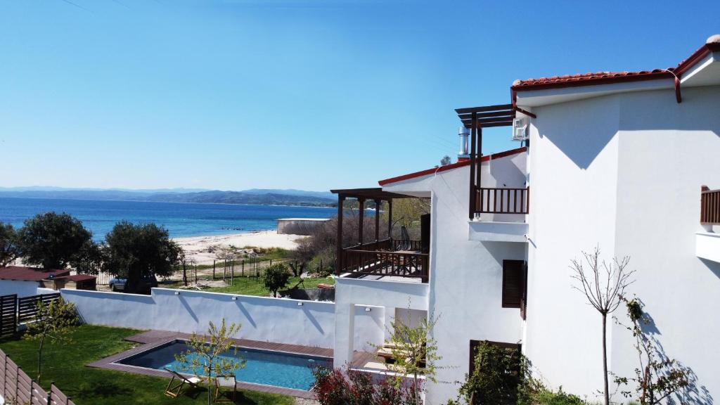 a white building with a view of the beach at Athos Villas in Ouranoupoli