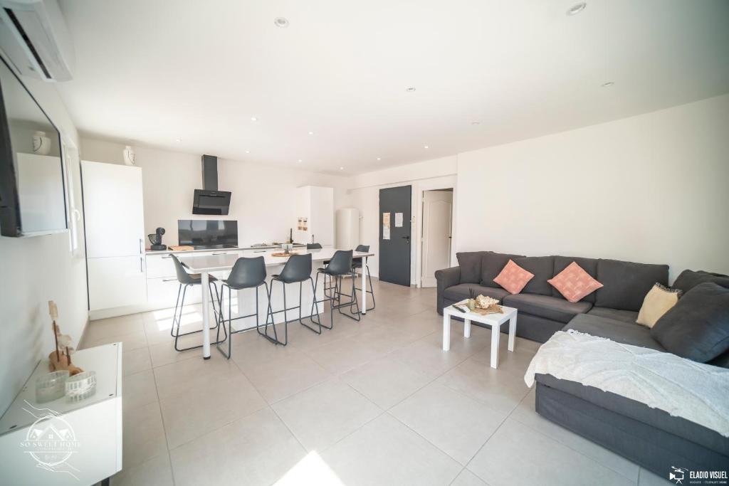 a living room with a couch and a kitchen at Les Embruns - Mer - Terrasse in Le Grau-du-Roi