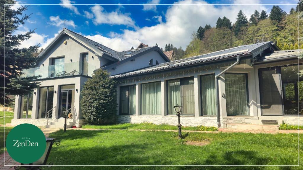 a house with a lawn in front of it at Sinaia ZenDen - Private Villa & SPA in Sinaia