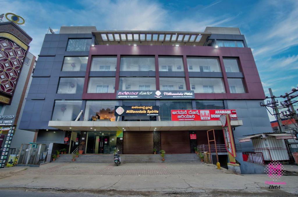 a large building with a motorcycle in front of it at Millennials Hotel in Kammasandra