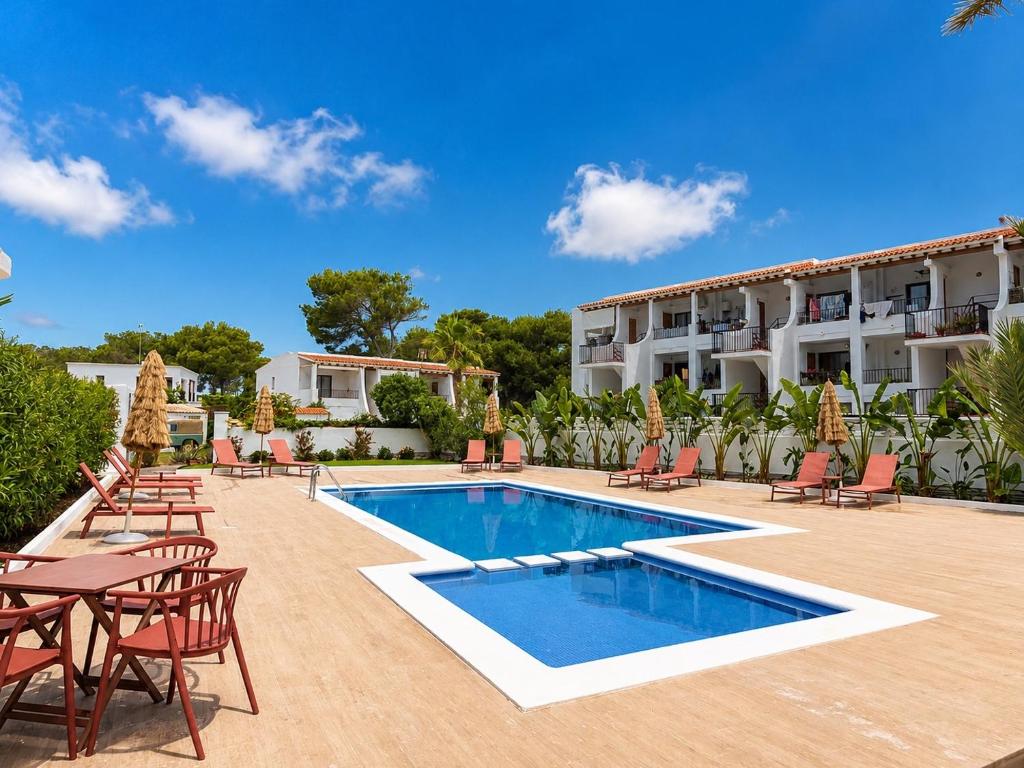 a resort with a swimming pool and tables and chairs at The Loft House Ibiza in Santa Eularia des Riu